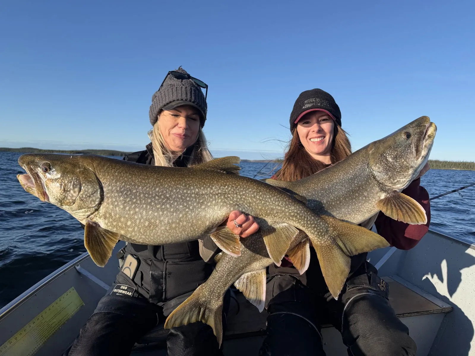 Two anglers each holding a big lake trout during a double on Kamuchawie Lake